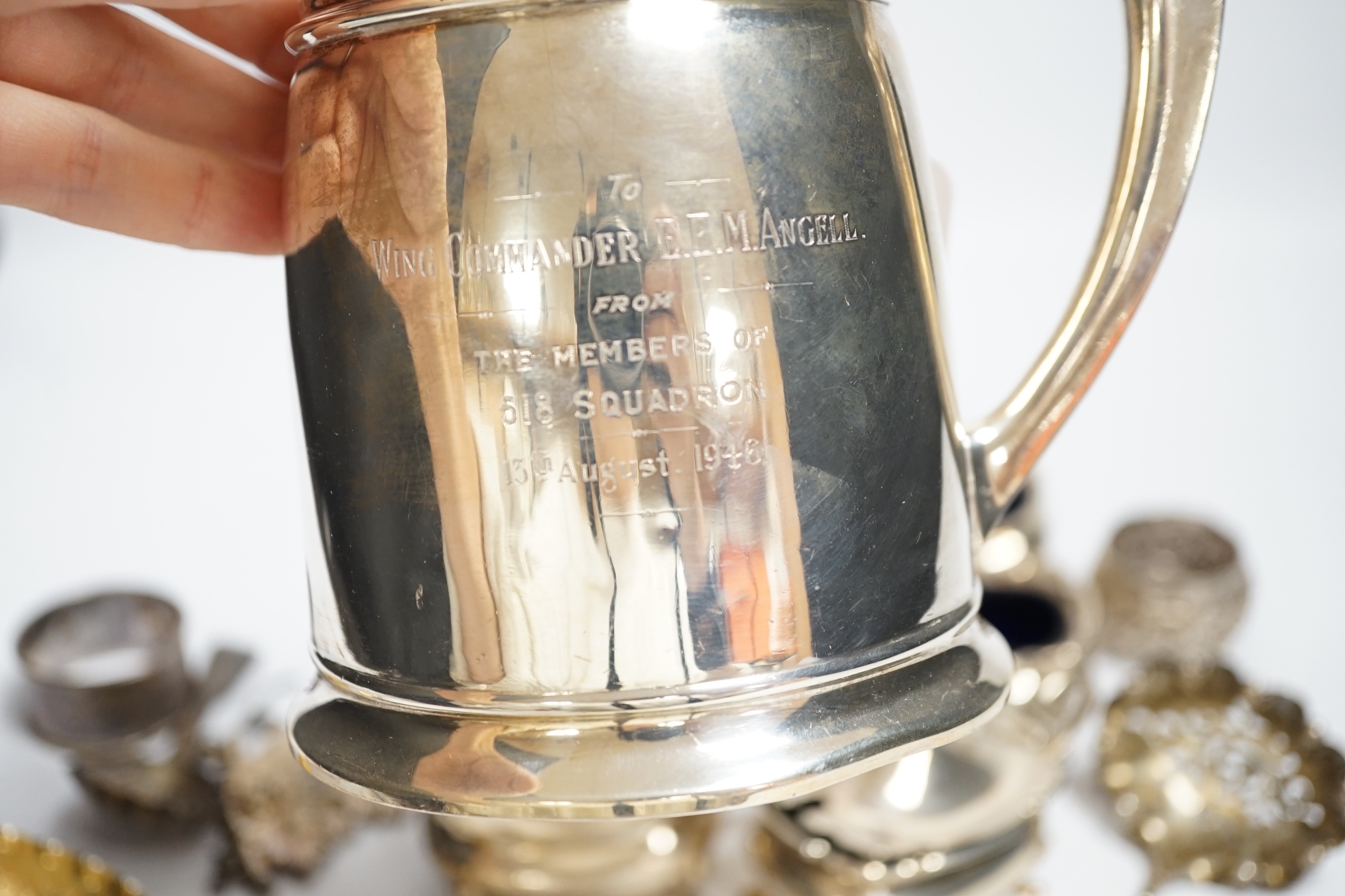 A George VI silver mug, Birmingham, 1937, 11.5cm with engraved inscription to Wing Commander E.E.M Angell, a pair of George III Old English pattern berry spoons, a George IV silver caddy spoons and other items including